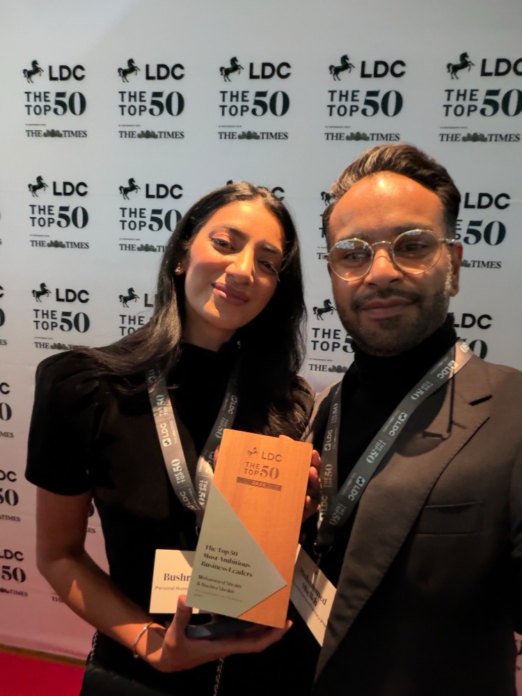 Bushra and Mohammed Sheikh holding the LDC Top 50 trophy in front of the LDC and The Times backdrop