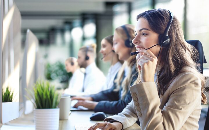 A row of patient support advisers taking calls at their desks