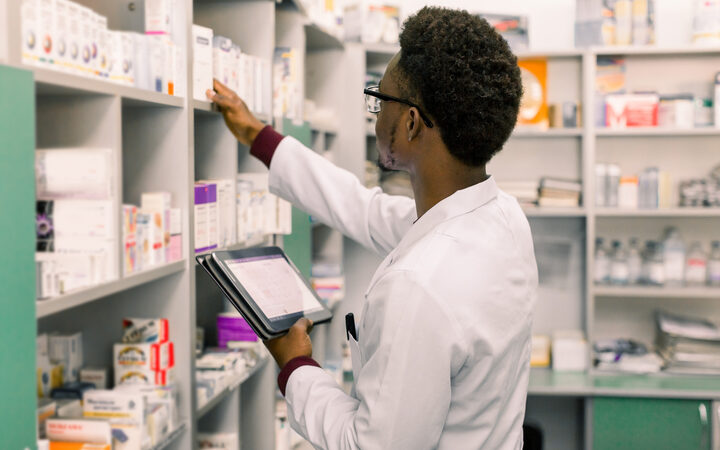 A pharmacist picking a box from the dispensary shelves
